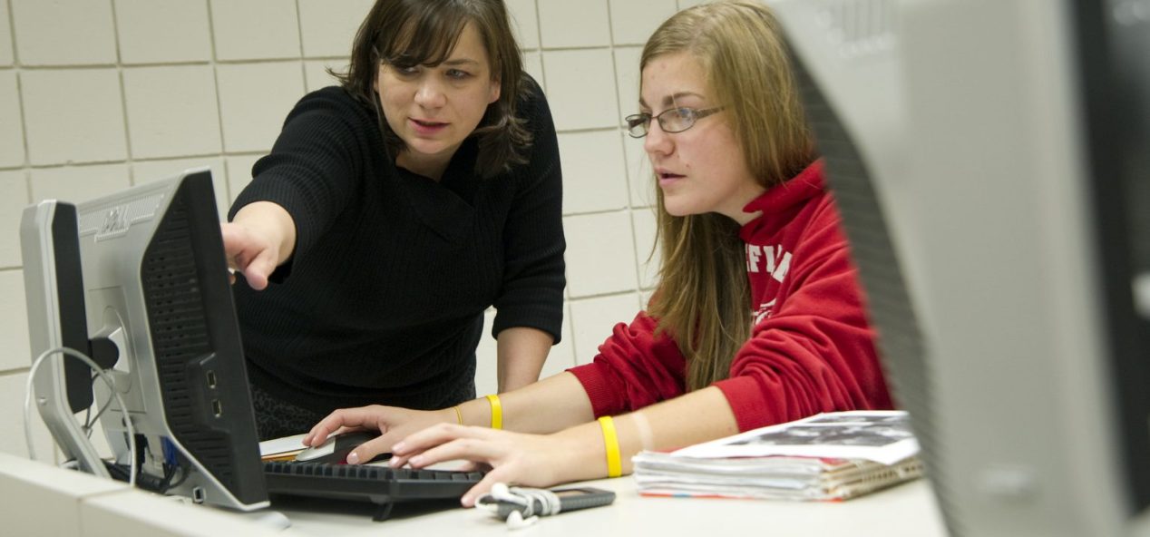 student & instructor at computer