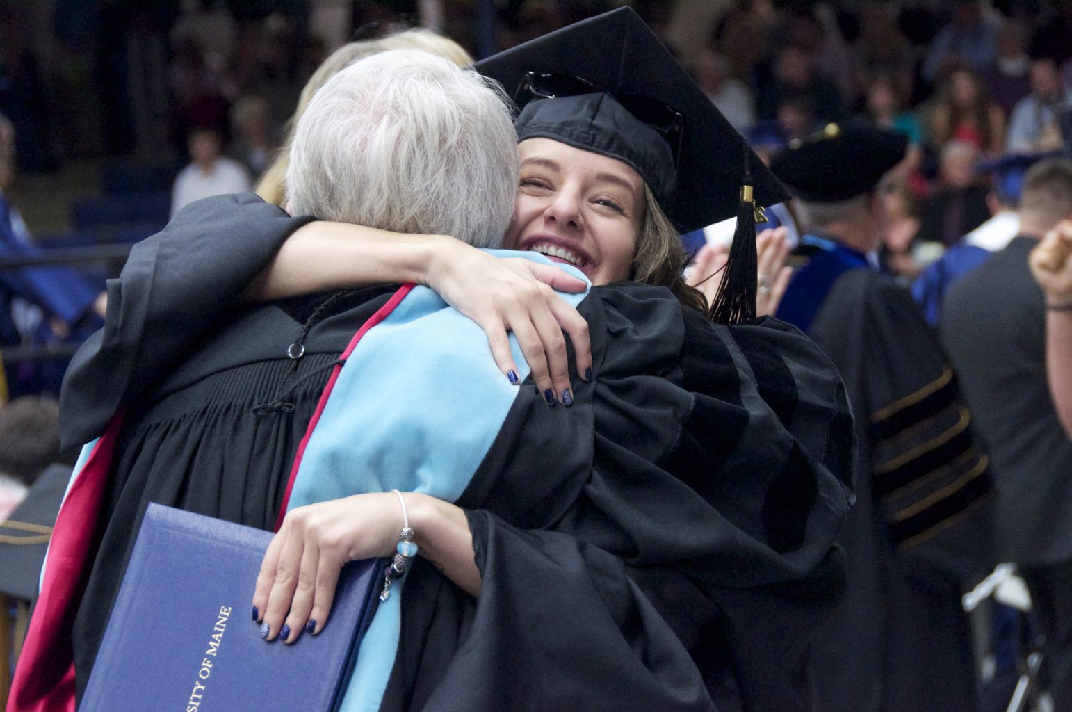 Two students hugging at commencement