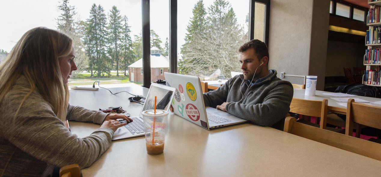 two students working on computers at desk