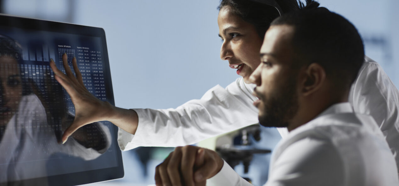 Scientists Working on Computer In Modern Laboratory NOTE TO INSPECTOR: all graps, dna models,