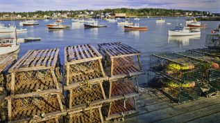 Wooden Lobster Traps On A Dock With Fishing Boats