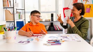 Disabled pupil and his teacher doing math