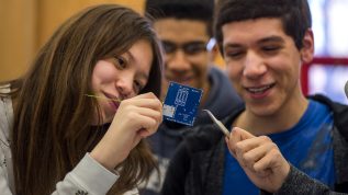 Two students holding a computer chip