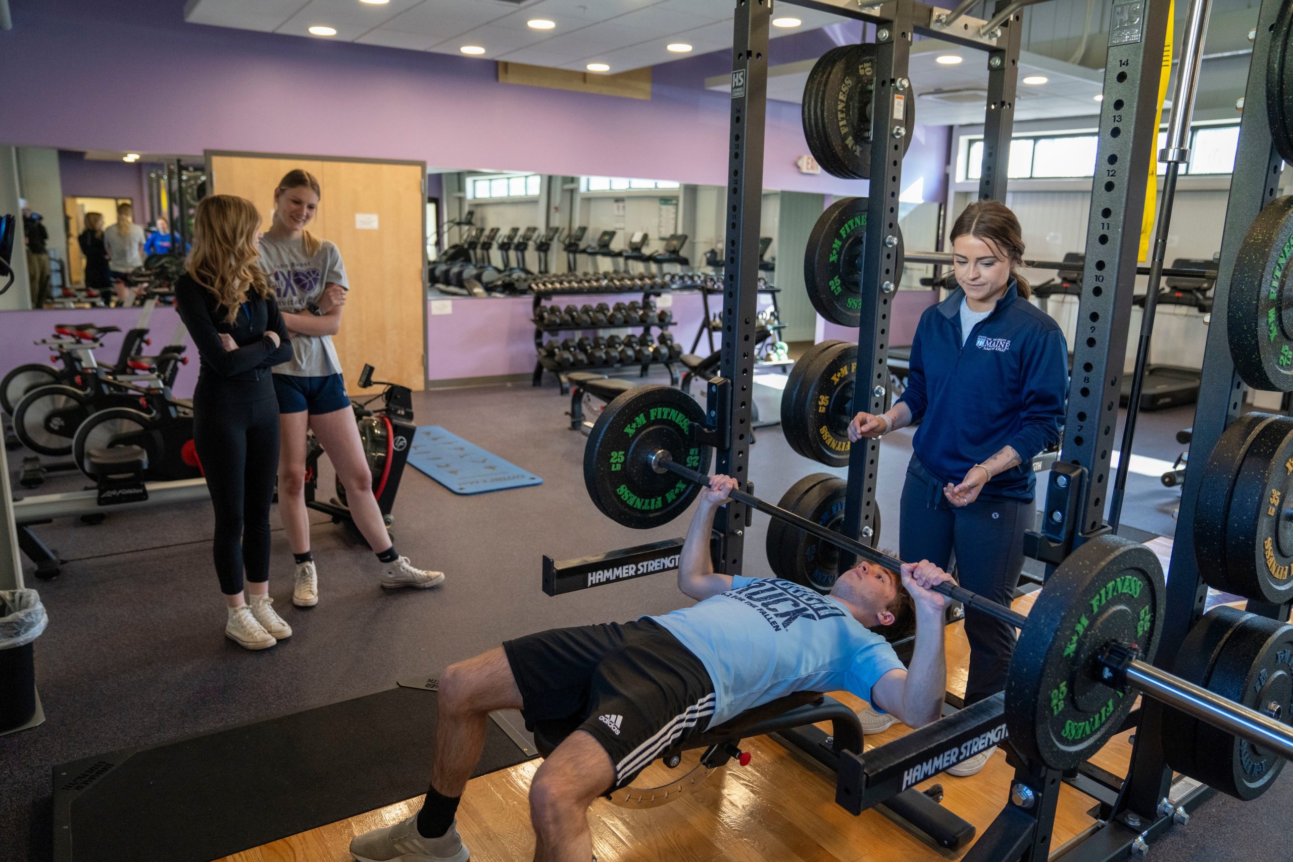 Teacher helps a student in the weight room