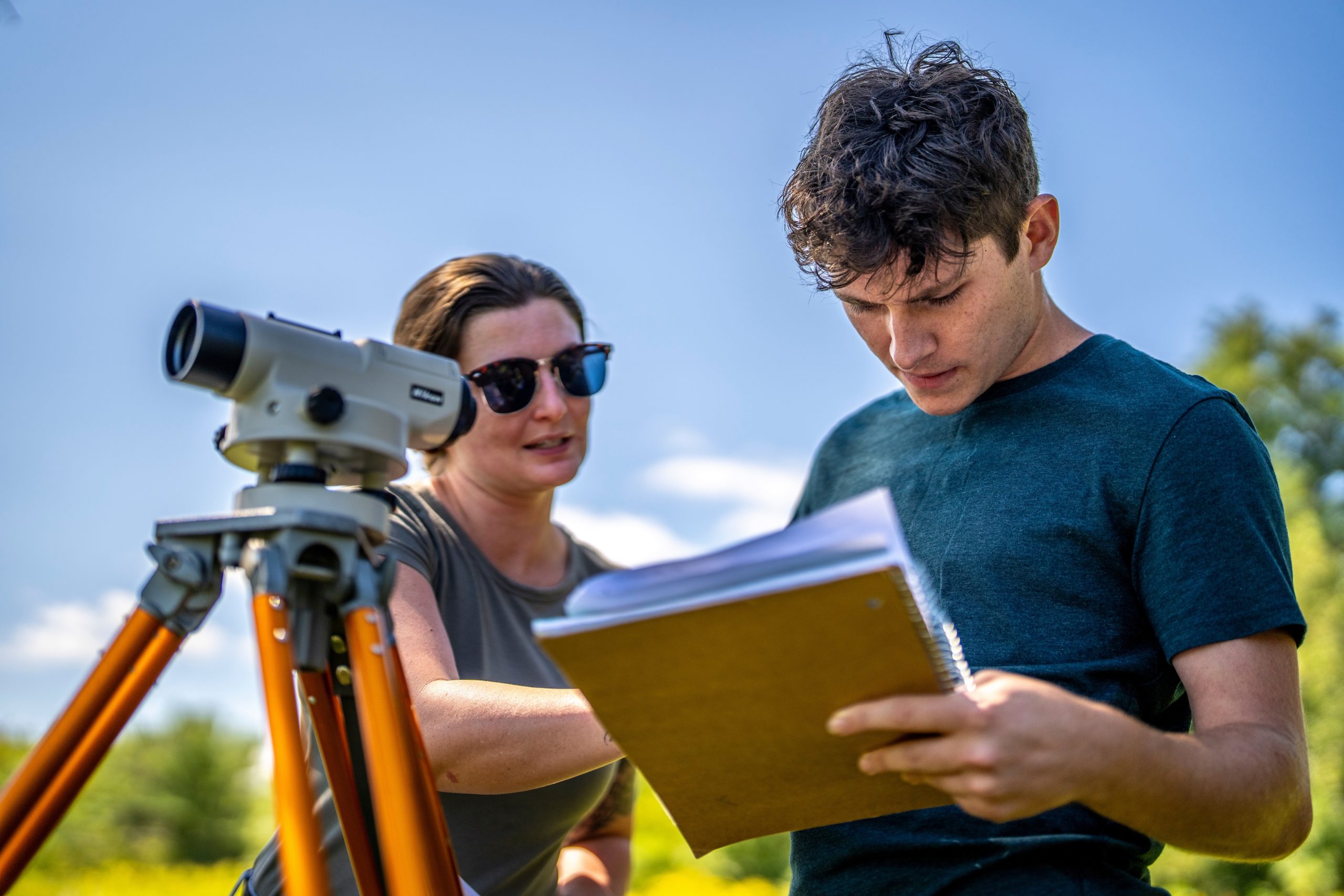 two people using surveying equipment