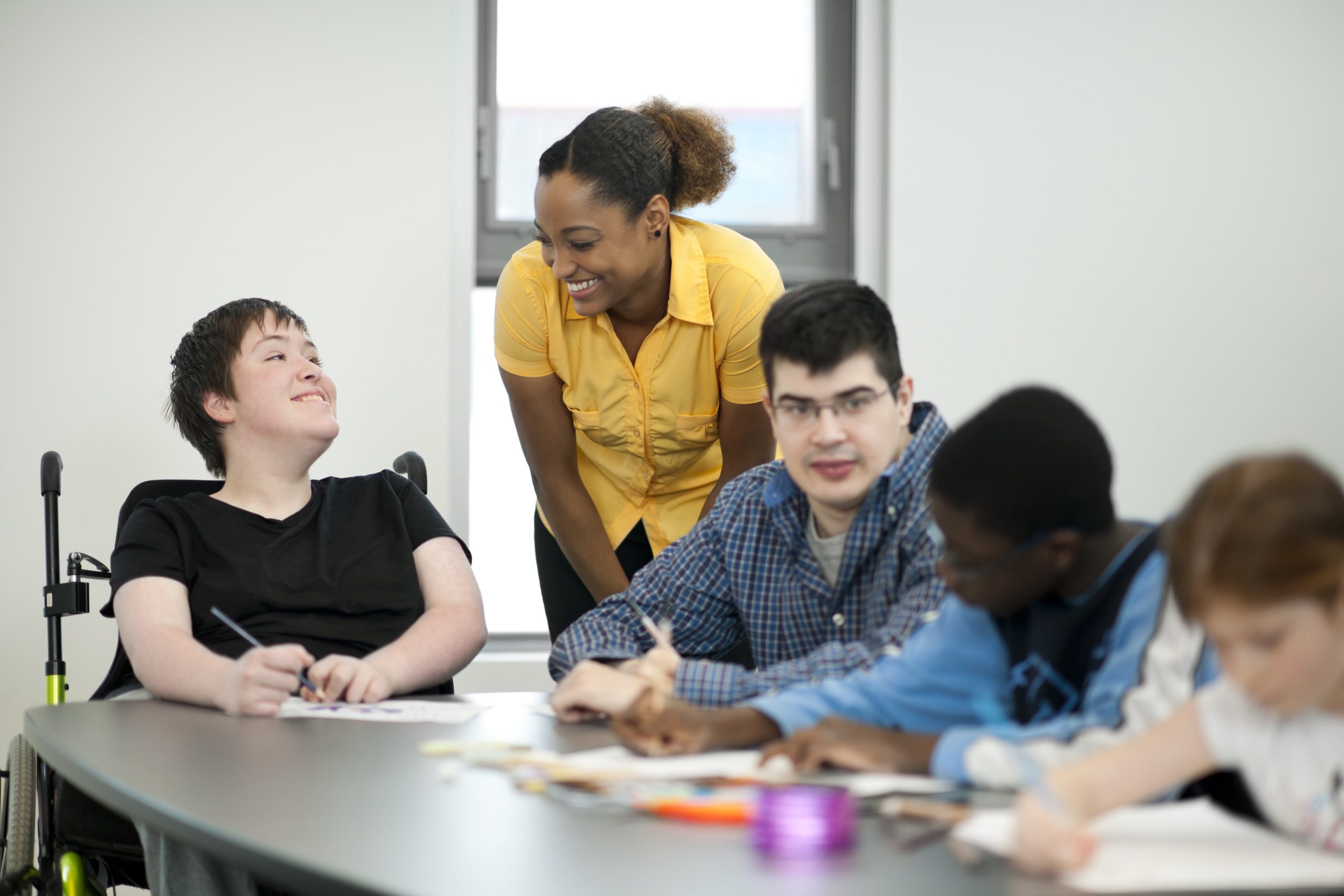 Teacher working with students with disabilities in a classroom