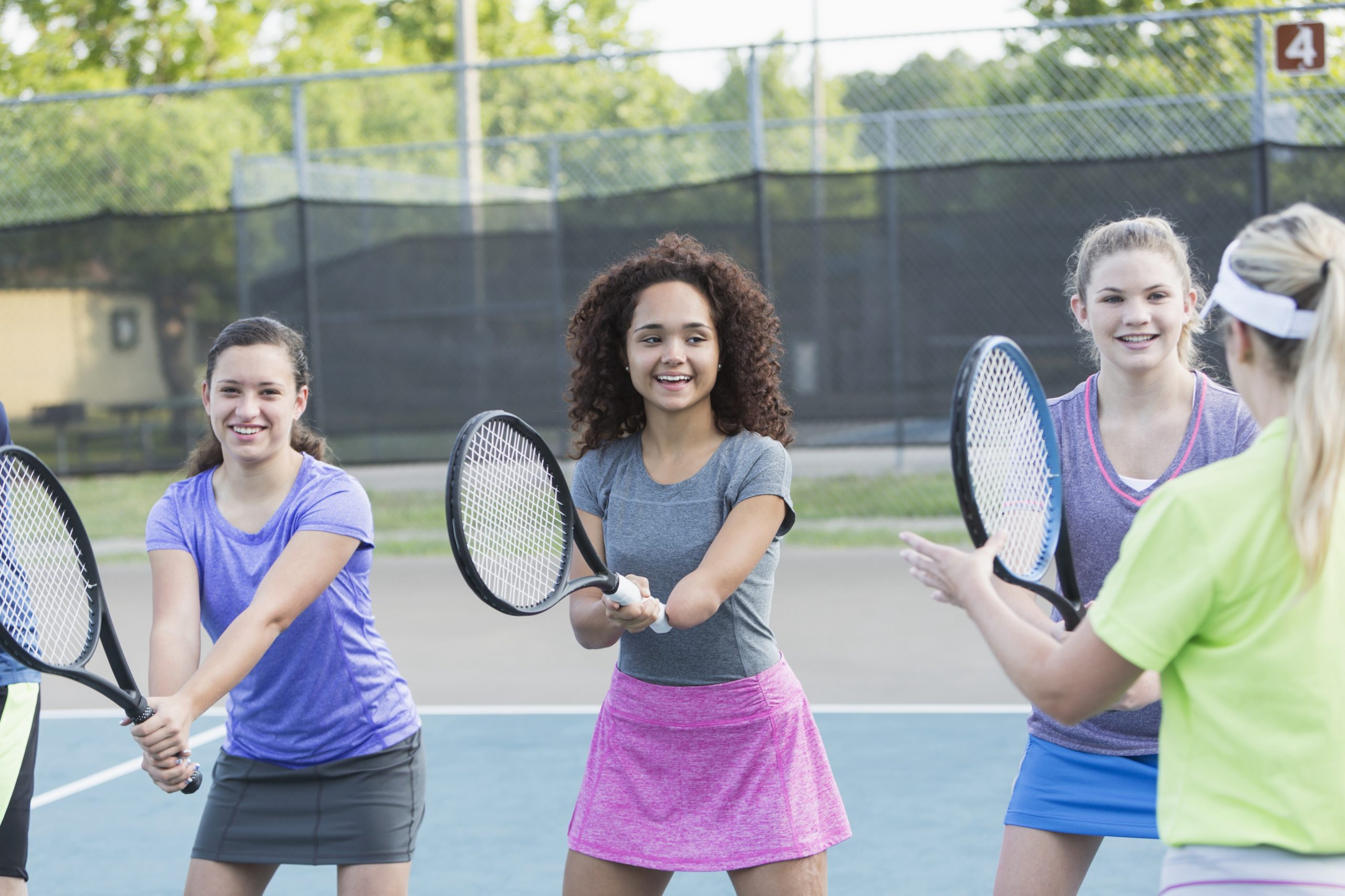 High school students playing tennis