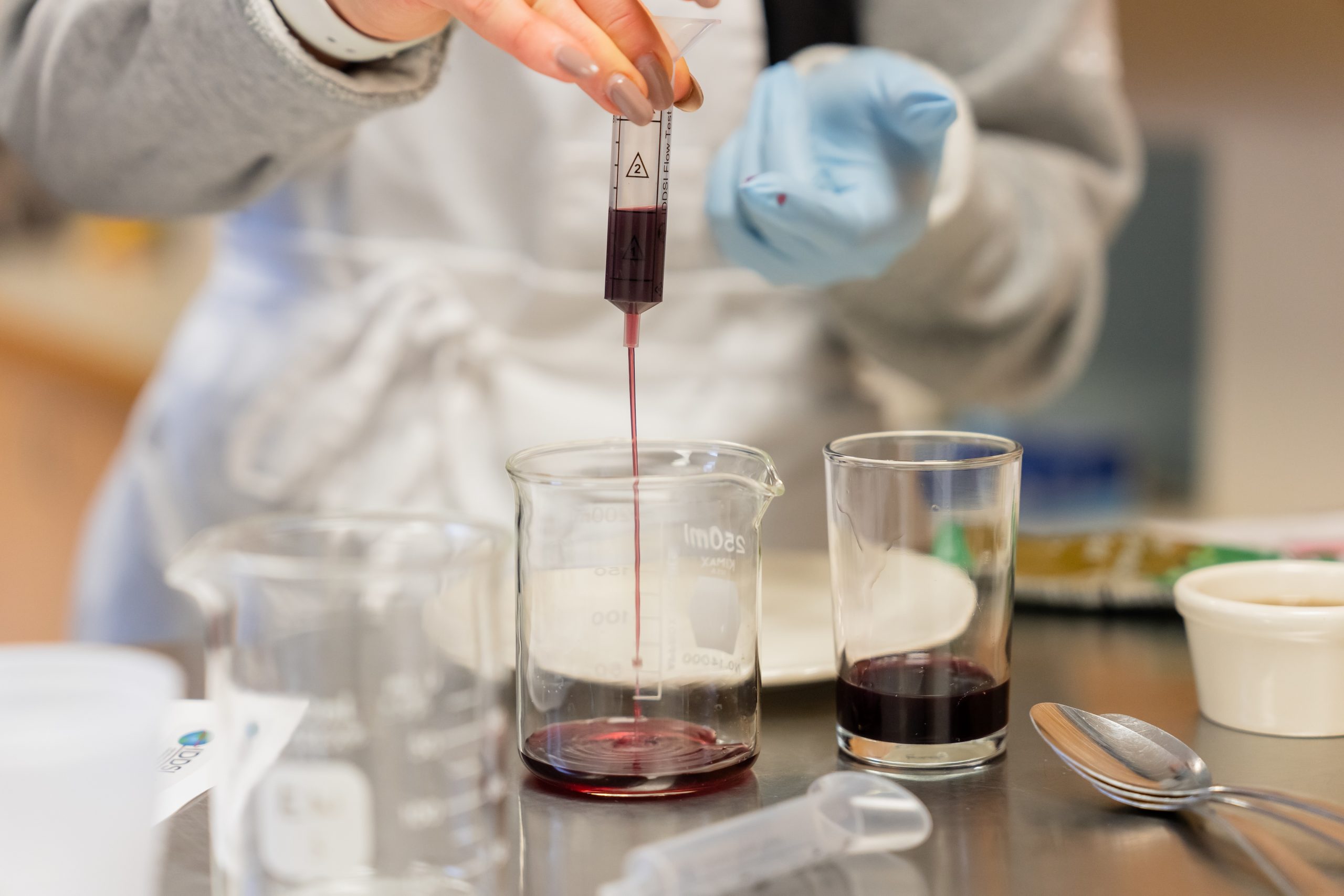 Person pouring blended food into beaker