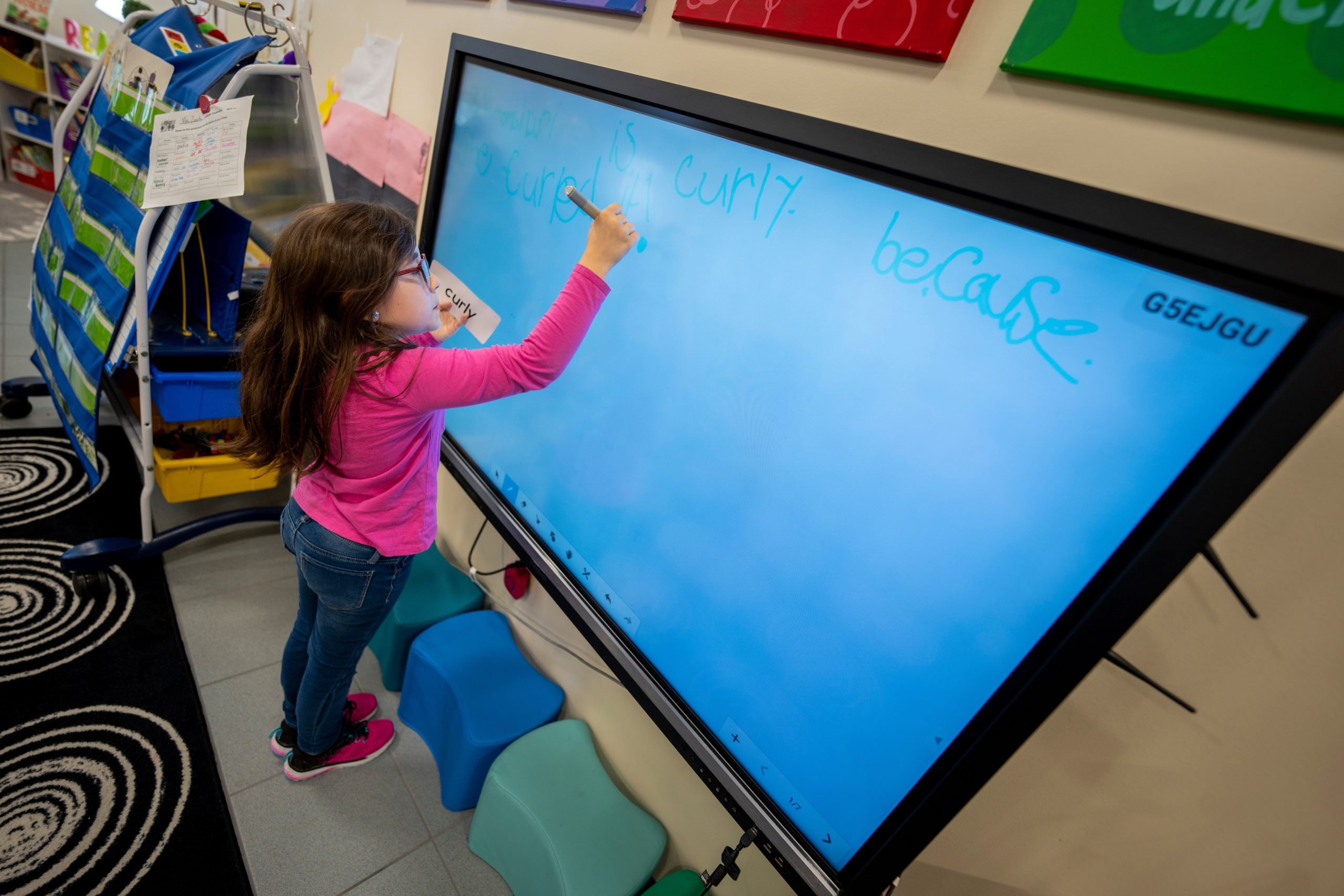 A teacher writing on a smartboard.