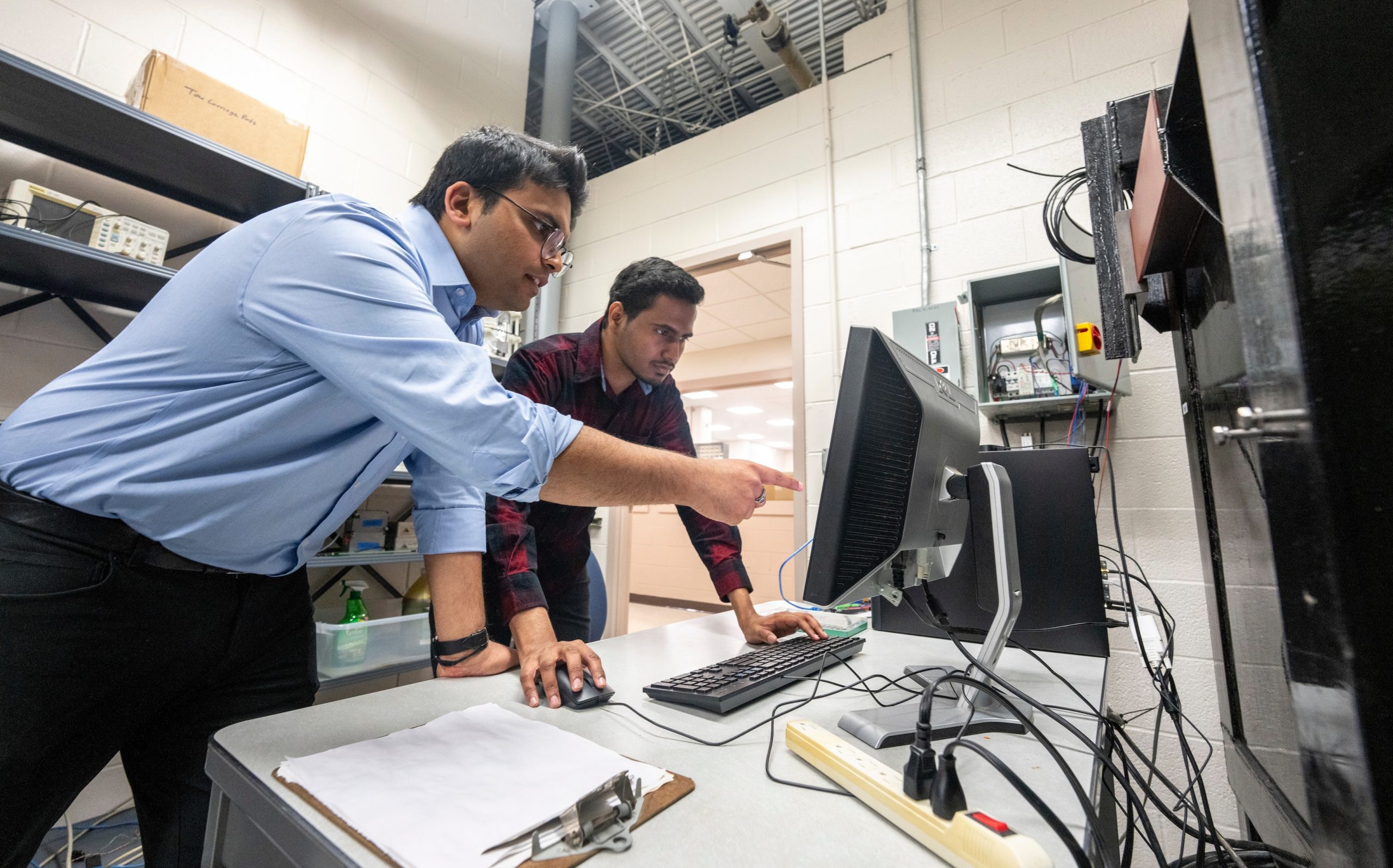 Two people looking at computer in a engineering lab