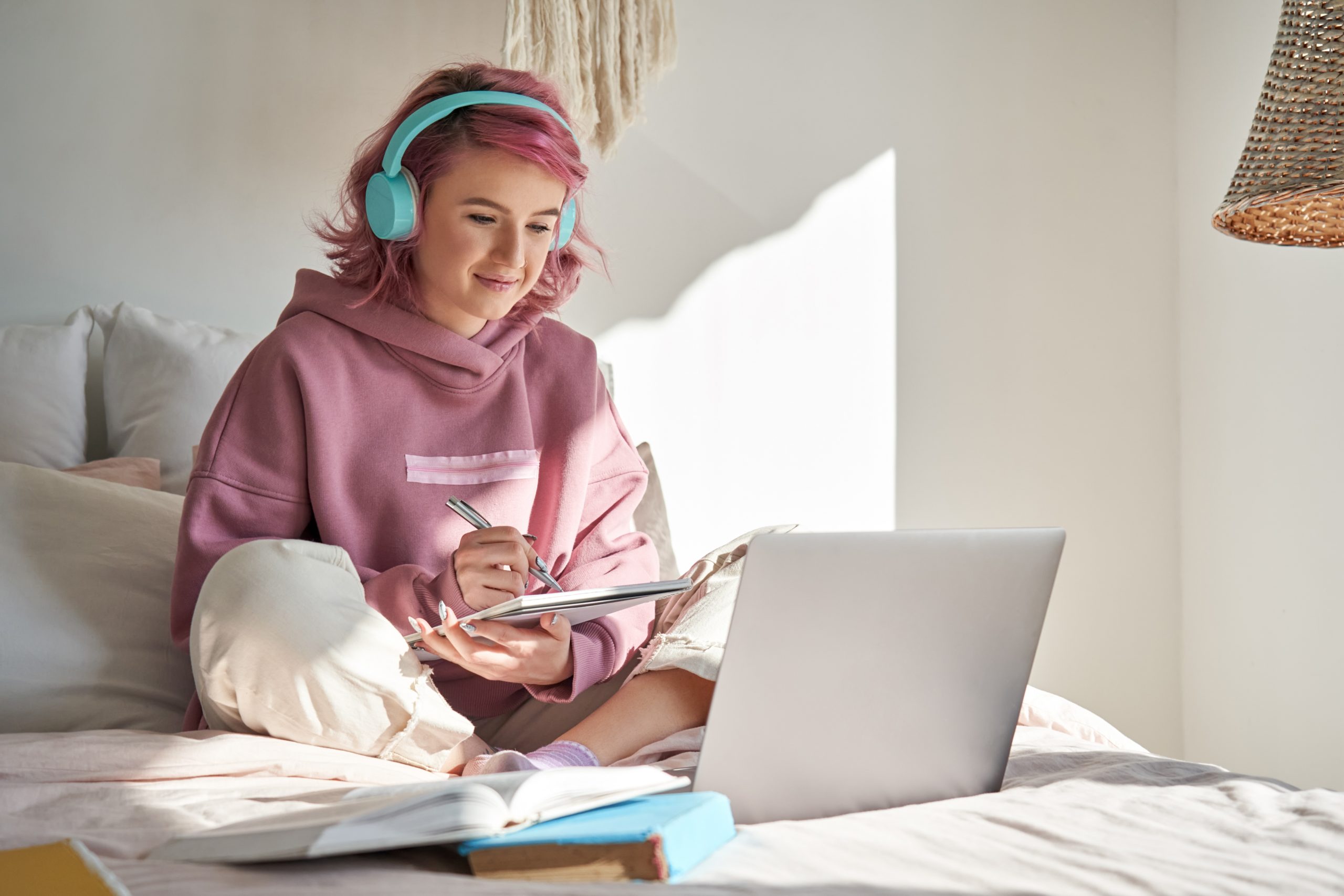 Student taking notes during an online class.