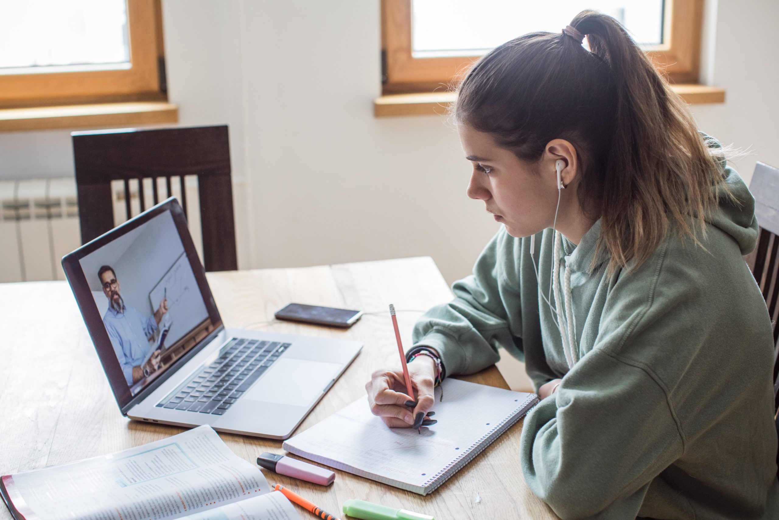 Student taking notes during an online class.