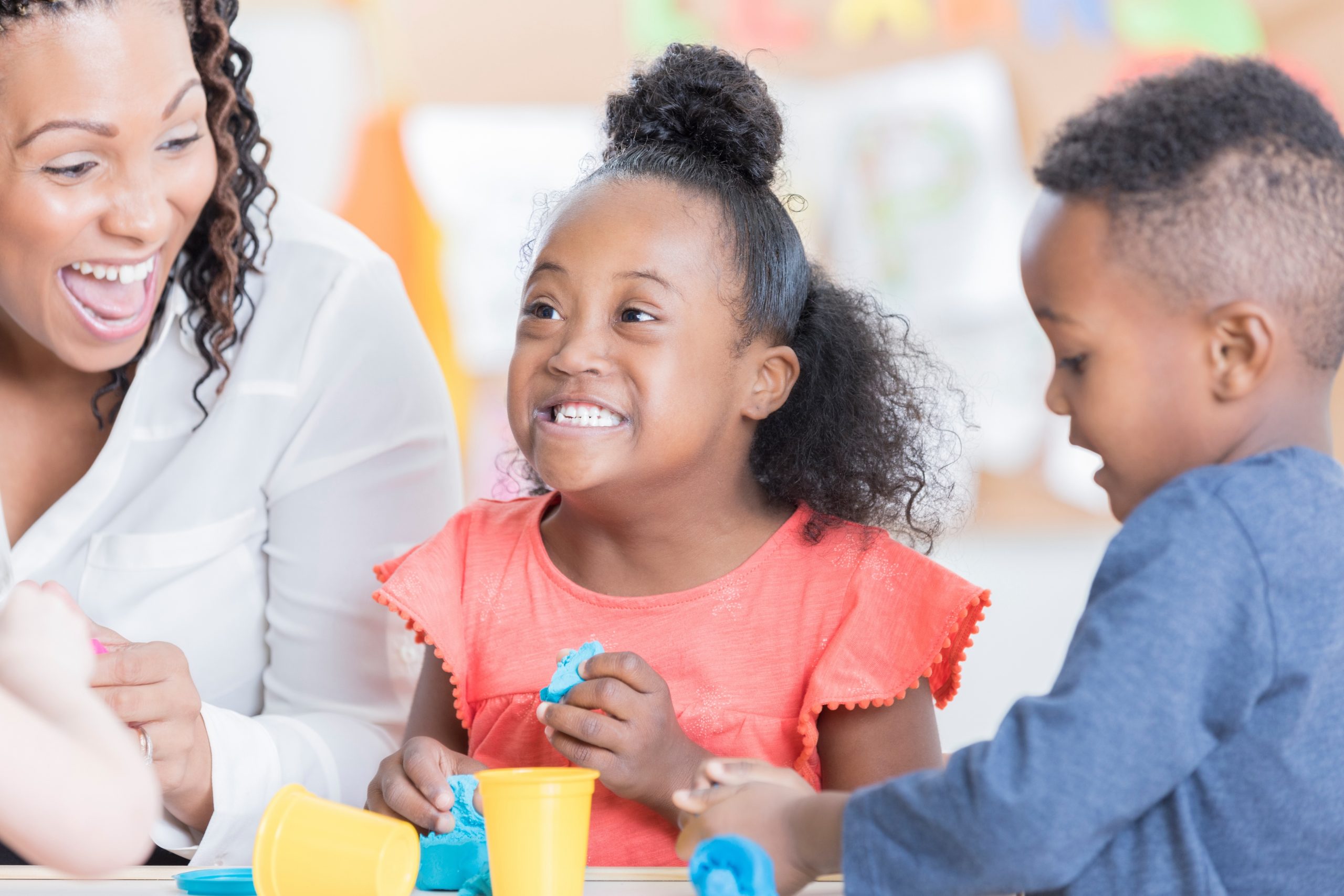 Young child with disabilities with another student and teacher