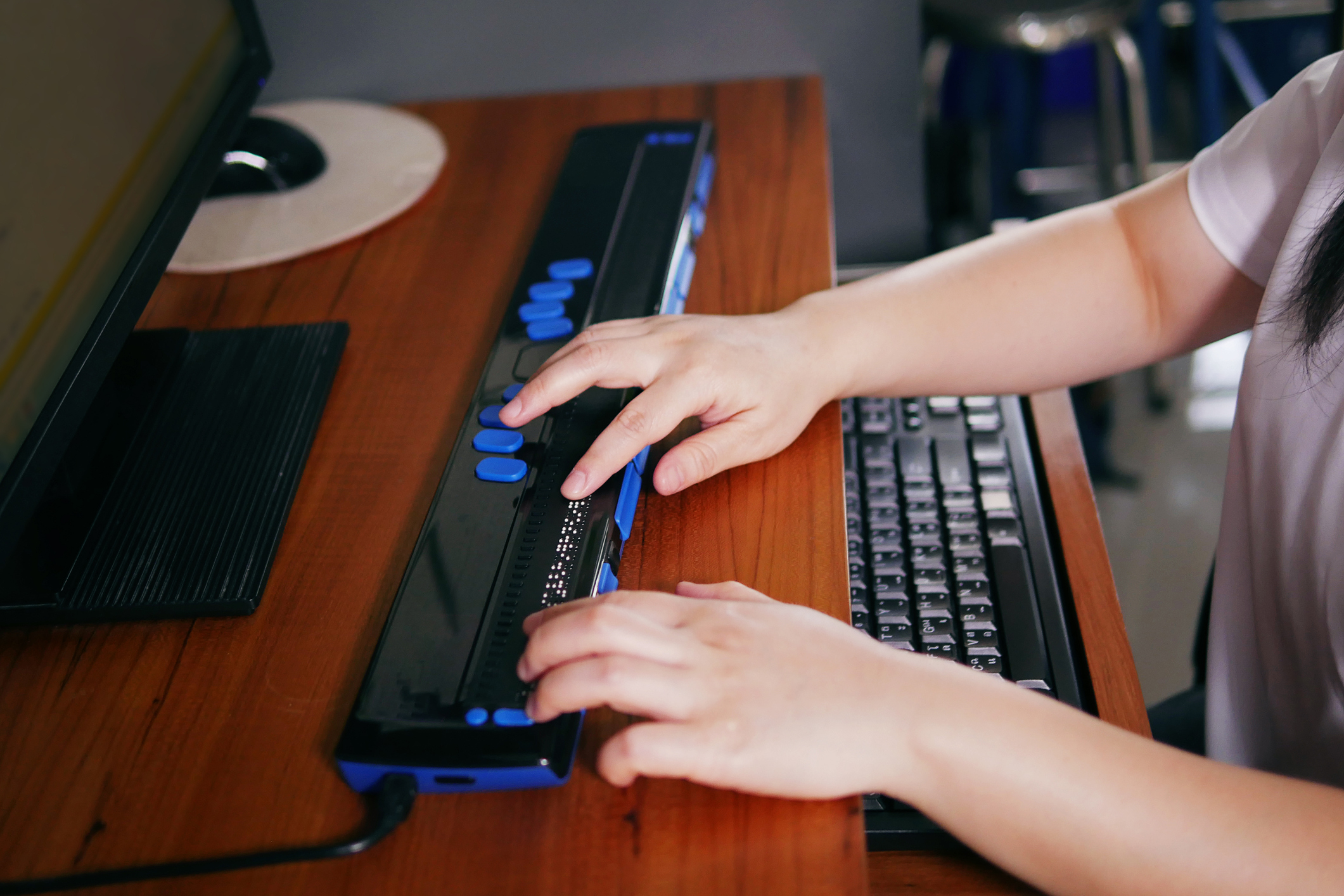 Person using a braille terminal for persons with visual impairment.