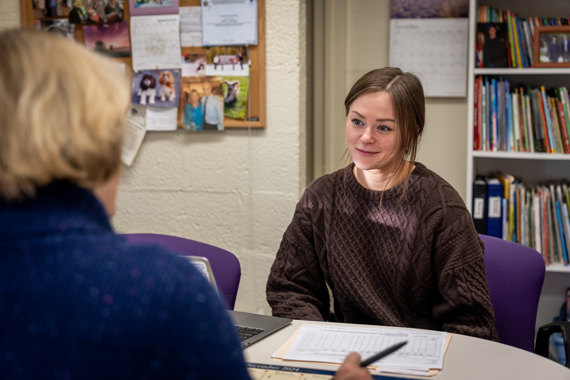 Student talking with a professor at a table